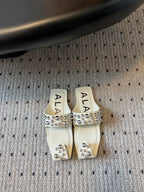 ALAIA FOLDED FLAT MULES WITH SPHERES ON WHITE CALFSKIN
