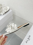 ALAIA FLAT MULE IN WHITE GLOSSY LAMBSKIN